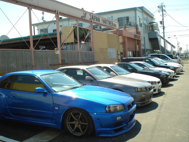 Japan Partner team inspecting cars in the yard